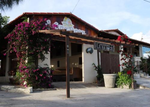 a restaurant with flowers on the front of it at Lá na Roça - Belezas do Monte Chalé, Suítes & Restaurante in Monte das Gameleiras