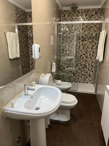 a bathroom with a sink and a toilet and a shower at Residencial Solar da Estação in Barcelos