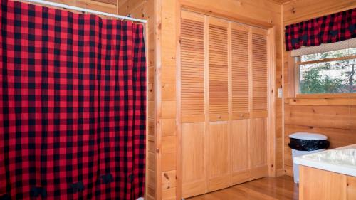 a bathroom with a plaid shower curtain and a window at Red Apple Mountaintop cabin hot tub, WiFi, Pet friendly, Fireplace, pit, BEST VIEWS in Cherry Log