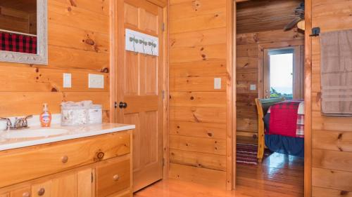 a bathroom with a sink and a mirror at Red Apple Mountaintop cabin hot tub, WiFi, Pet friendly, Fireplace, pit, BEST VIEWS in Cherry Log