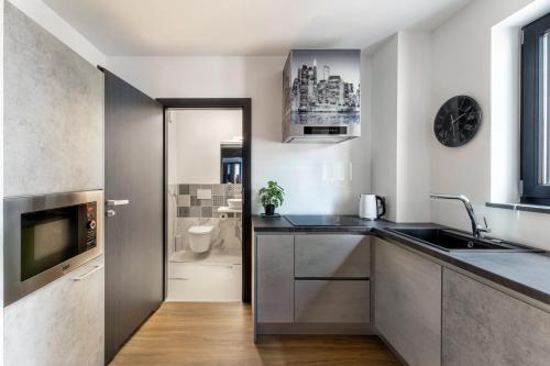 a kitchen with a sink and a toilet in a bathroom at Apart House, Tylna 20 in Zielona Góra