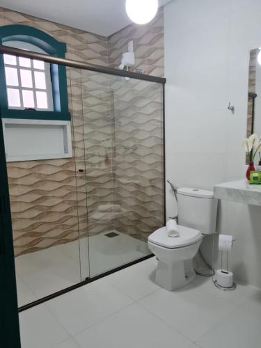 a bathroom with a shower and a toilet at Pousada Candelabro in Tiradentes