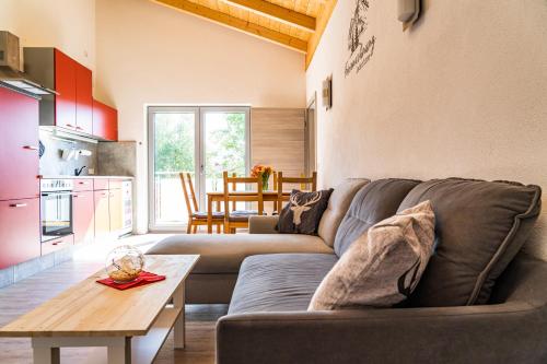 uma sala de estar com um sofá e uma mesa em Gästehaus Beim Huber em Hopferau