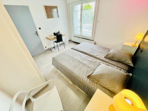 a bedroom with a bed and a desk and a window at Flatshare Colocation 4 close to Geneva in Saint-Genis-Pouilly