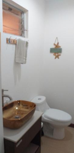 a bathroom with a wooden sink and a toilet at Pura Vida Condo in Tamarindo