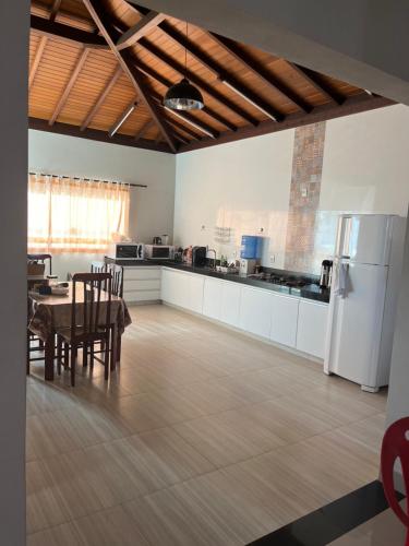 eine Küche und ein Esszimmer mit einem Tisch und einem Kühlschrank in der Unterkunft Casa Família Paraíso in Capitólio