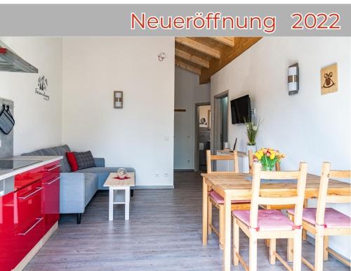 a kitchen and a living room with a table and chairs at Gästehaus Beim Huber in Hopferau