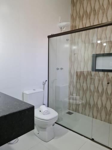 a bathroom with a toilet and a glass shower at Pousada Candelabro in Tiradentes