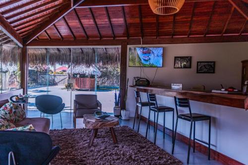 a bar in a living room with chairs and a table at Hotel de Charme Illuminare Stile in Fortim