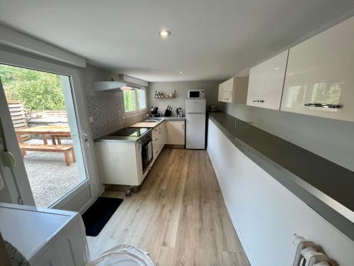 a kitchen with white appliances and a large window at Maison de ville Atypique - centre ville in Lannion