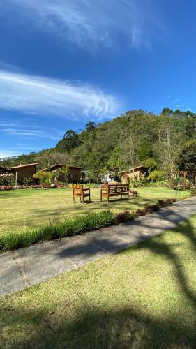 two benches in a park with a grass field at Terra Verde Visconde de Mauá in Visconde De Maua