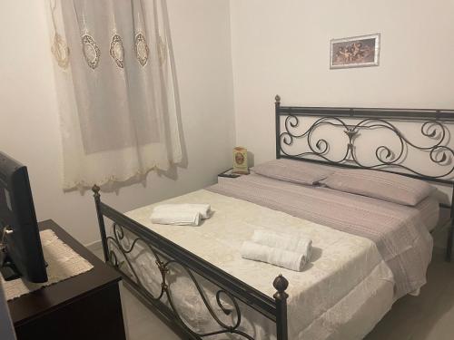 sypialnia z czarnym łóżkiem i 2 ręcznikami w obiekcie Villa aretusa w mieście Belvedere