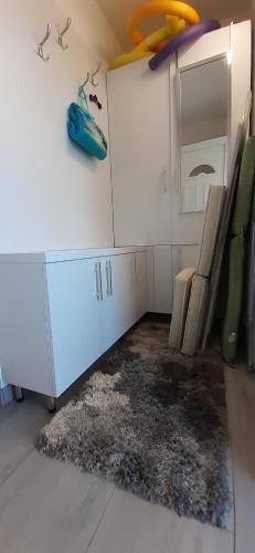 a room with a white cabinet and a rug at Apartman for You in Gyenesdiás
