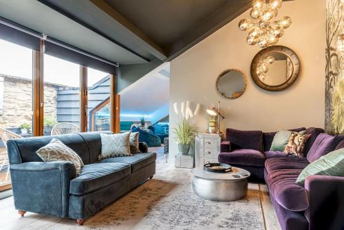 a living room with purple couches and a chandelier at Style & opulence in Georgian chapel w Parking in Bath