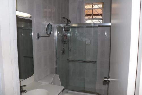 a bathroom with a shower with a toilet and a sink at Little Reef Villa in Saint James