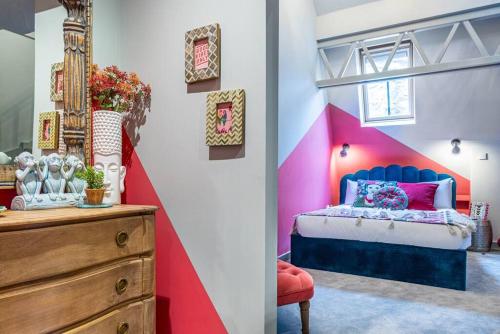 a bedroom with a blue and pink bed and a dresser at Style & opulence in Georgian chapel w Parking in Bath