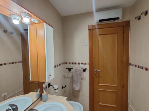 La salle de bains est pourvue d'un lavabo et d'un miroir. dans l'établissement Ático Granada al Sol (terraza vistas montaña), à La Zubia
