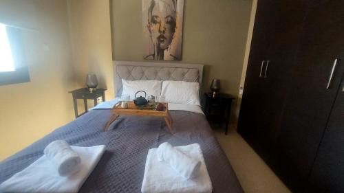a bedroom with a bed and a table with towels at Paramount Gardens Resorts C201 in Larnaca