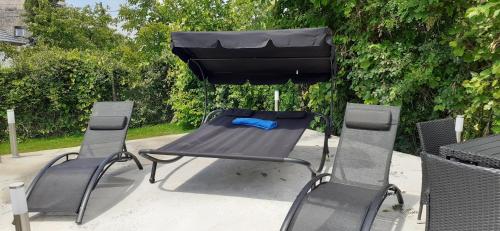 a picnic table with two chairs and an umbrella at Apartman for You in Gyenesdiás