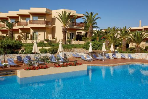 a resort with a swimming pool with chairs and umbrellas at Giannoulis – Santa Marina Beach Hotel in Agia Marina Nea Kydonias