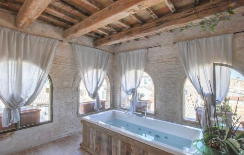 uma banheira num quarto com janelas em Dimora Pallotto em Potenza Picena