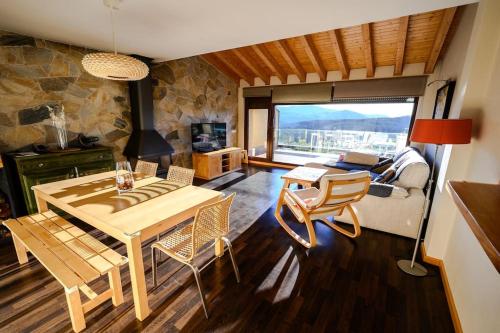 uma sala de estar com uma mesa e cadeiras e um sofá em La Portilla de Gredos. Casa rural em Hoyos del Espino