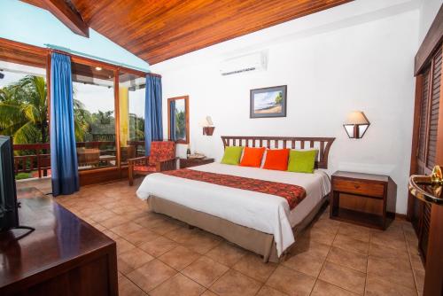 a bedroom with a bed and a television in it at Nandel Beach Resort in La Cruz