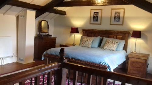 a bedroom with a large bed with a wooden headboard at The Barn - Trelash, North Cornwall in Warbstow