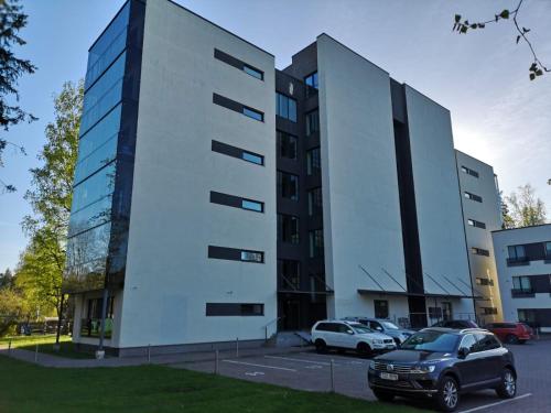 a building with cars parked in a parking lot at Vabaduse tn 72 in Narva-Jõesuu