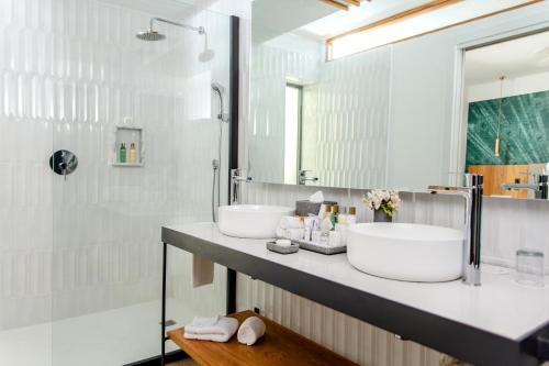 a bathroom with two sinks and a shower at Dreams Flora Resort & Spa in Punta Cana