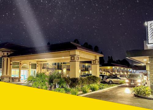 a building with cars parked in a parking lot at night at Bposhtels Anaheim in Anaheim