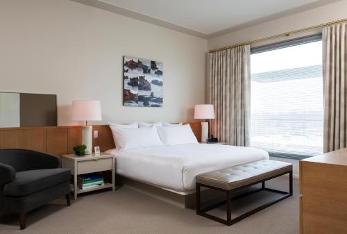 um quarto com uma cama, uma cadeira e uma janela em 21c Museum Hotel Bentonville - MGallery em Bentonville