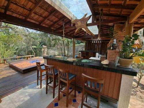 an outdoor kitchen with a bar and a deck at MANSION BOHEMIA in Búzios