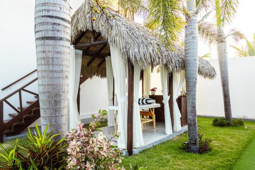 a small cottage with a table and palm trees at Hotel de Charme Illuminare Stile in Fortim