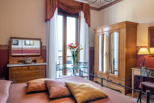 a bedroom with a bed and a table and a window at Pinto-Storey Hotel in Naples