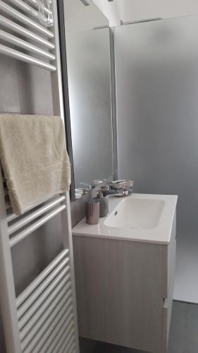 a white bathroom with a sink and a mirror at A casa di Anna in Finale Ligure