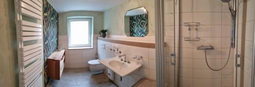 a bathroom with a sink and a toilet and a shower at Ferienwohnung Kraska in Hohenstein-Ernstthal