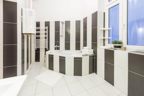 La salle de bains est pourvue d'une baignoire, d'un lavabo et d'une fenêtre. dans l'établissement Bourgeois Elegance in the heart of Budapest, à Budapest