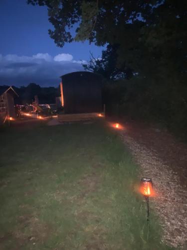 a yard at night with a light in the grass at Shepherds Hut with Scandinavian Hot Tub and hydromassager in Sway