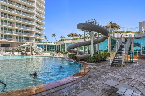 a swimming pool with a slide in a resort at Caribe Resort Unit C211 in Orange Beach