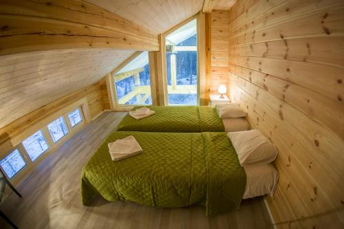 a bedroom with a green bed in a wooden cabin at Hapsal Holiday Homes in Haapsalu