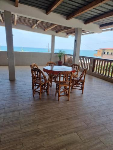 een patio met een tafel en stoelen op een balkon bij CRUCITALIA Departamento x 8 in Crucita