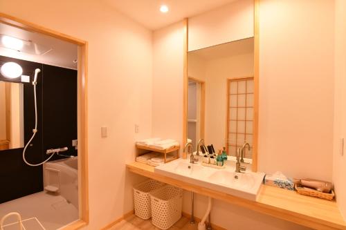 La salle de bains est pourvue d'un lavabo et d'un miroir. dans l'établissement FL House 浪花町, à Osaka