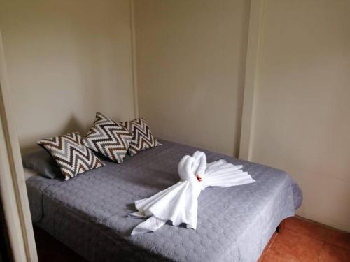 a bed with a white towel on top of it at La Casa del Río/La Fortuna/Volcán Arenal in San Ramón