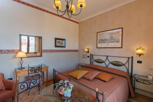 ナポリにあるPinto-Storey Hotelのベッドルーム1室(ベッド1台、ガラス張りのテーブル付)
