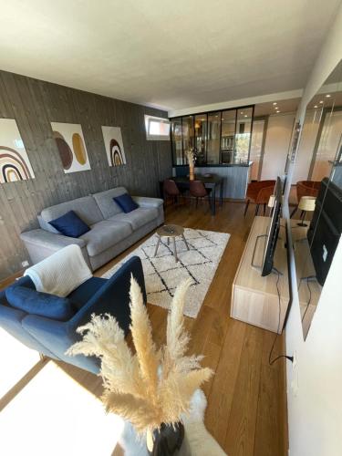 un salon avec un canapé et une télévision dans l'établissement Mizar, Joli appt rénové avec parking et balcon, à Courseulles-sur-Mer