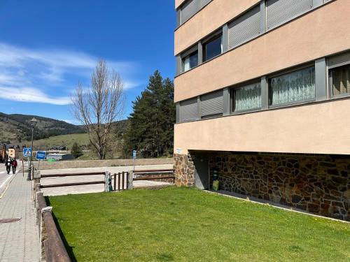 a building with a grass yard next to a building at Studio in Residencia Maresme Neu - La Molina in La Molina