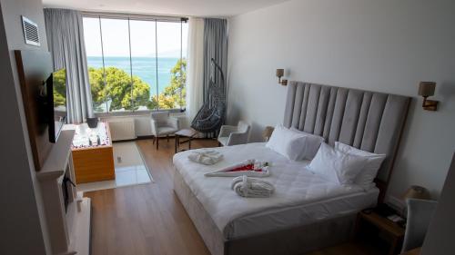 a bedroom with a white bed with a large window at Lake Life Hotel in İznik