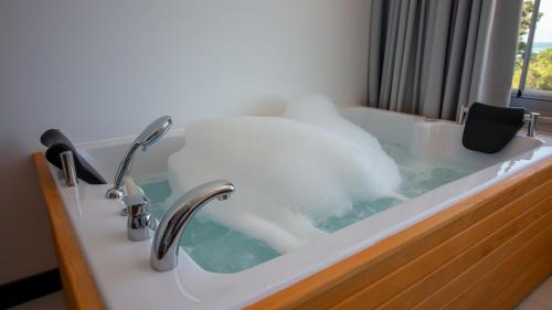 a bath tub filled with water next to a window at Lake Life Hotel in İznik