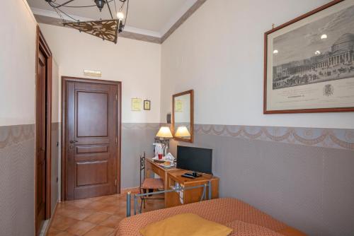 a bedroom with a bed and a desk with a computer at Pinto-Storey Hotel in Naples